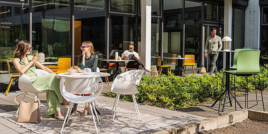 Mitarbeiter auf sonniger Terrasse trinken Kaffee